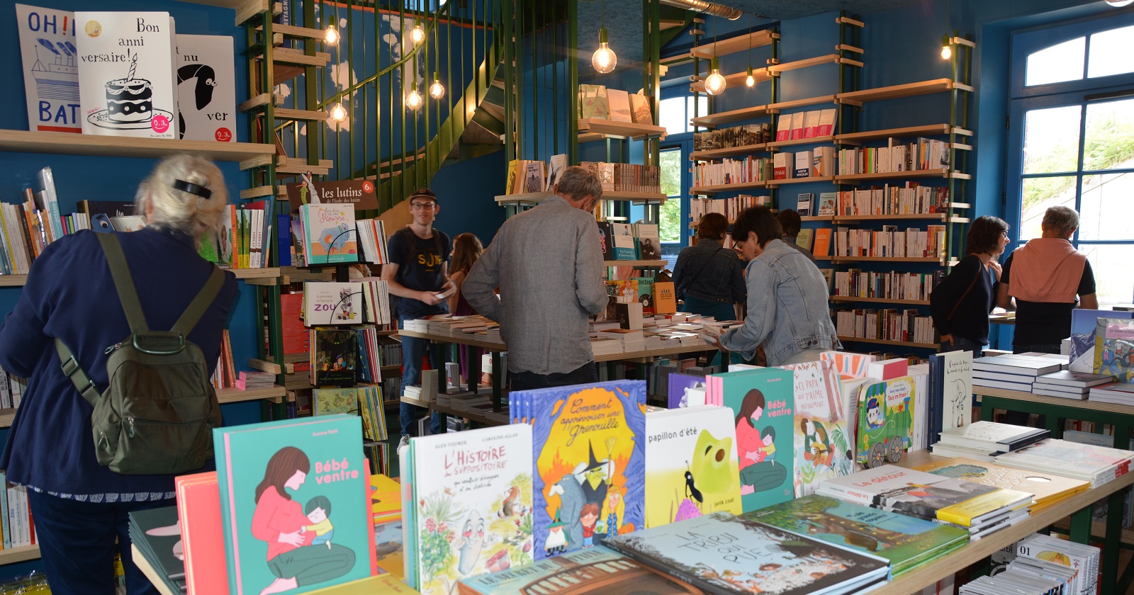 Libraire de la petite Gare. Au premier plan des livres, en arrière plan, plusieurs personnes consultant des livres