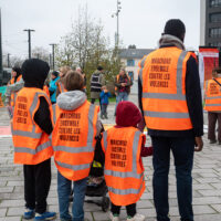 Une famille habillée de chasubles orange avec l'inscription "Marchons ensemble contre les violences", au départ de la marche contre les violences faites aux femmes.