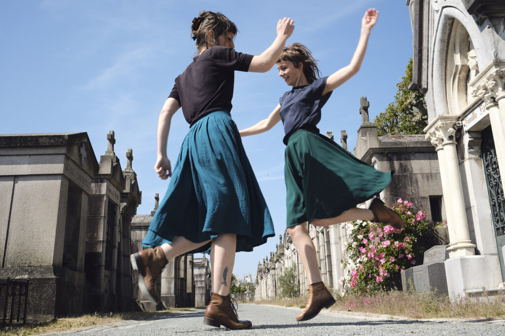 Deux femmes en train de danser dans un cimetière.